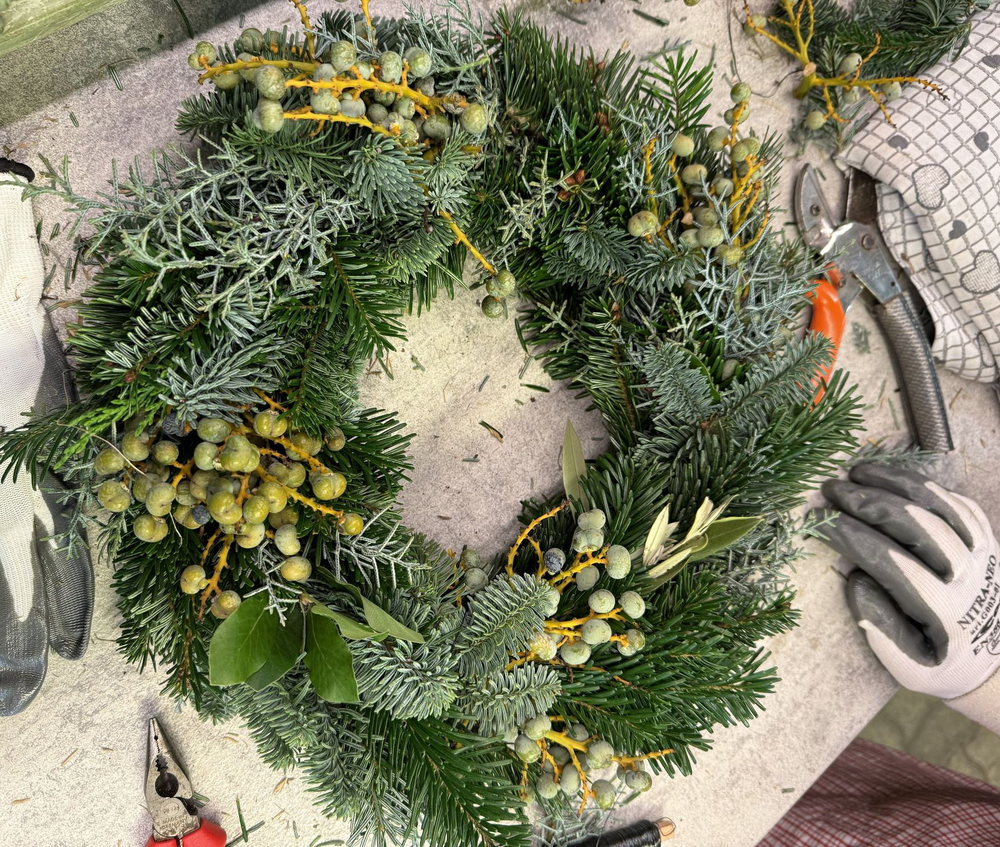 Una corona verde artigianale, realizzata da una partecipante al nostro workshop di creazione ghirlande a Bolzano.